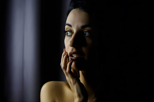 Woman with hand on face in dramatic lighting